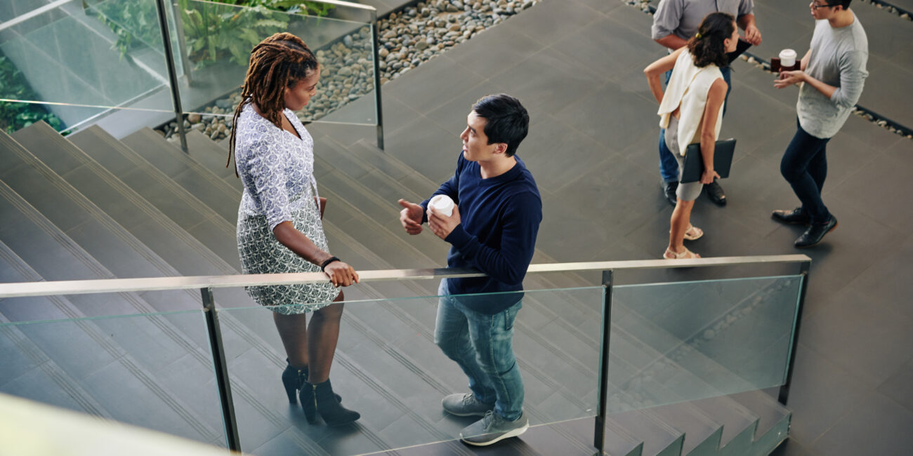 people standing on stairs and discussing project they are working on together