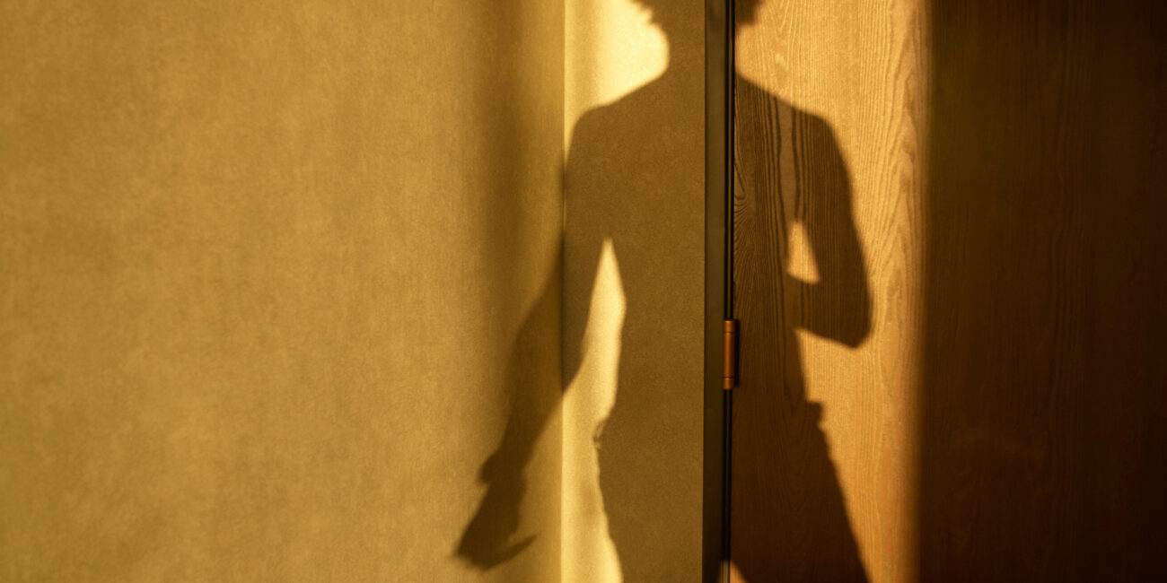 Shadow of man on hotel room door