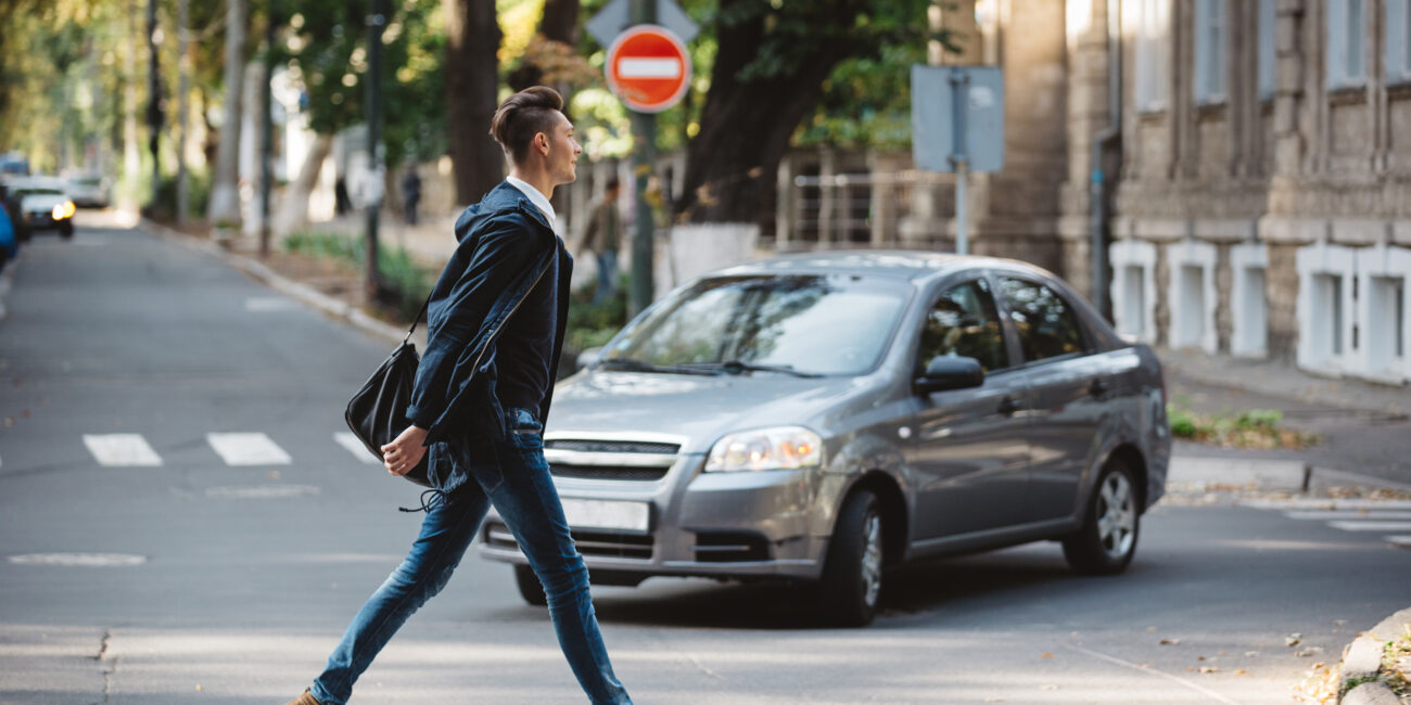 Young man crossing the street at a crosswalk