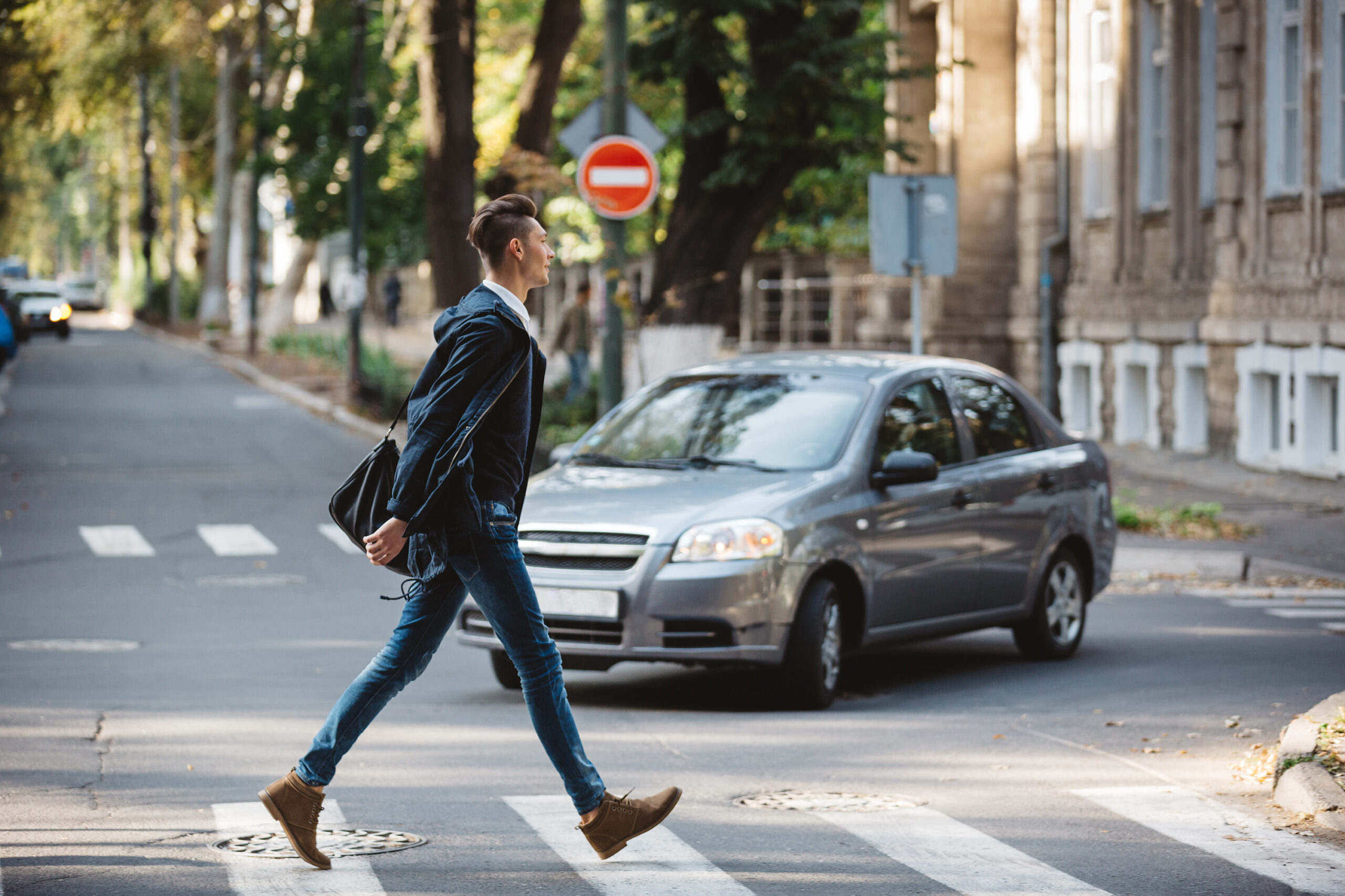 Young man crossing the street at a crosswalk