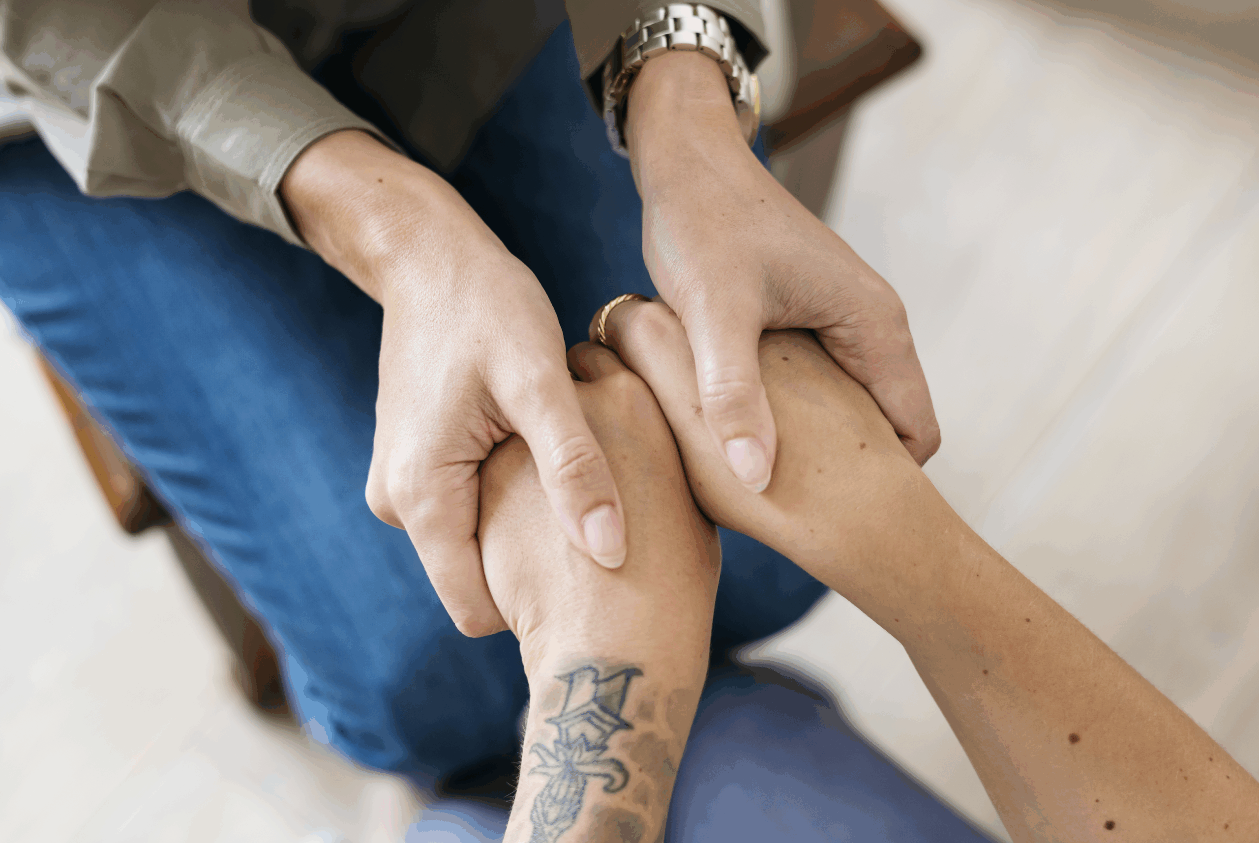 close up of hands of women holding hands in support of each other