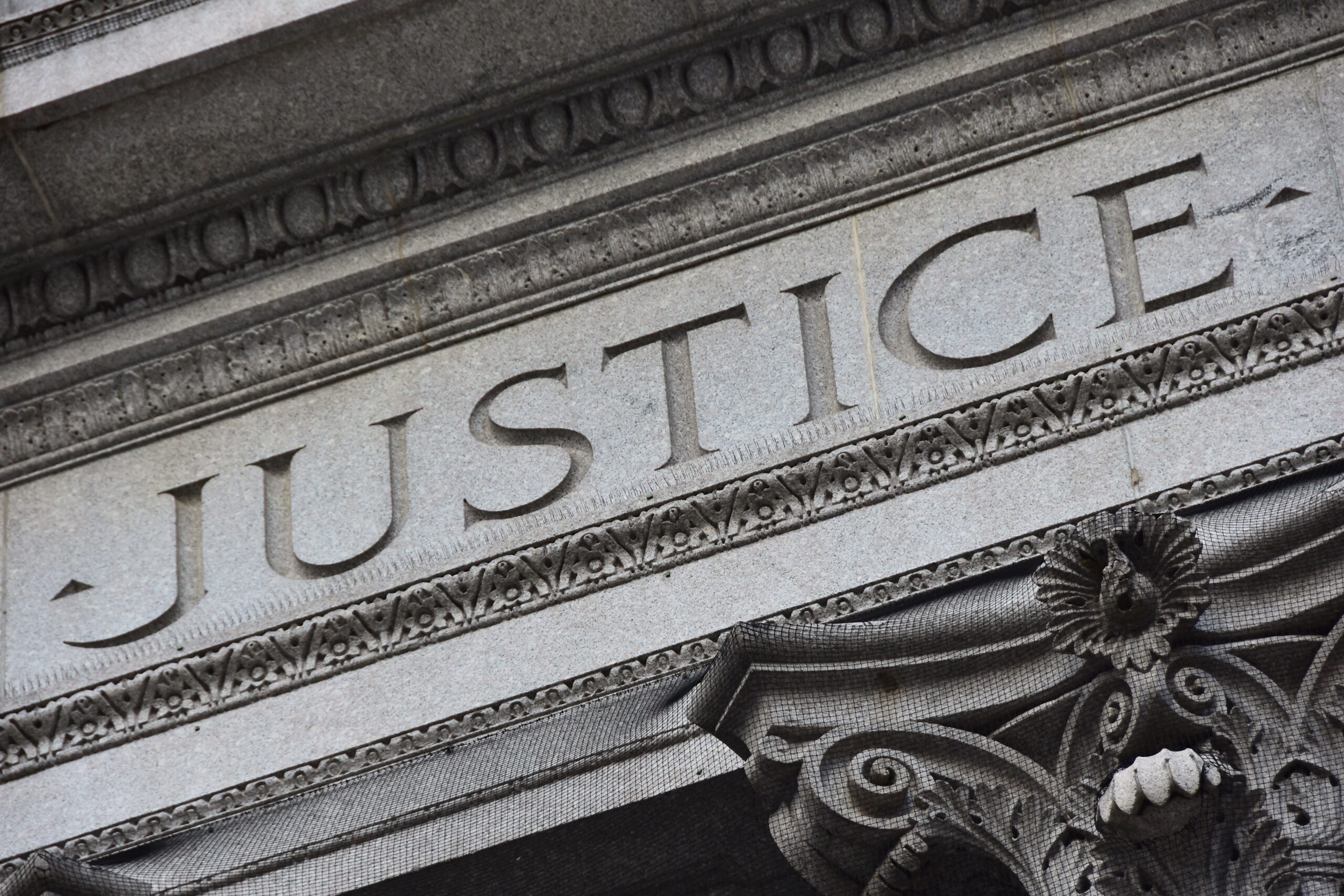 the word justice etched in stone