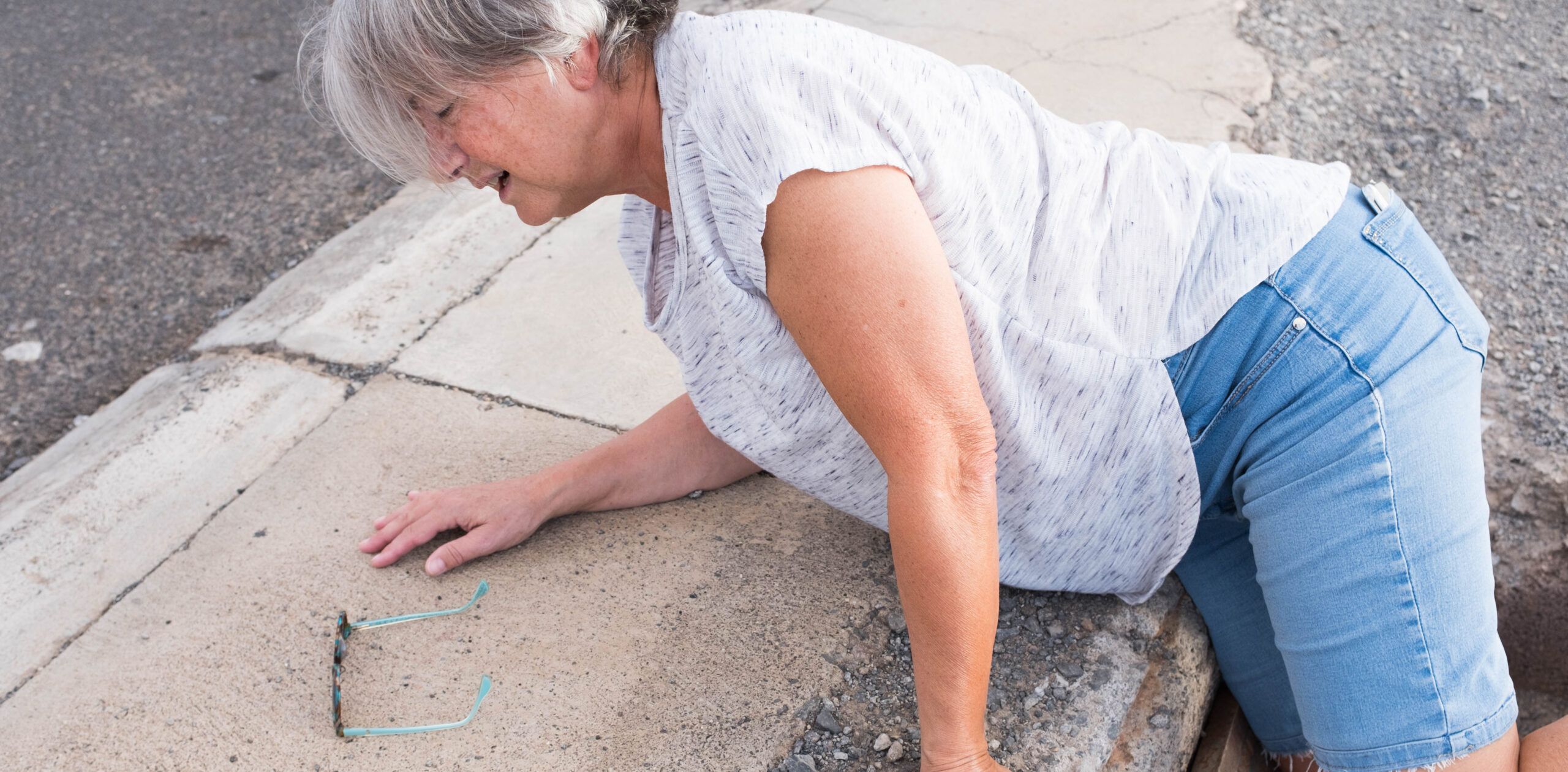 one mature woman fall in a street hole needing help
